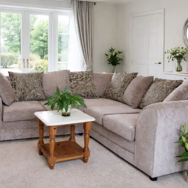 Grey fabric corner sofa with patterned scatter cushions in a modern living room